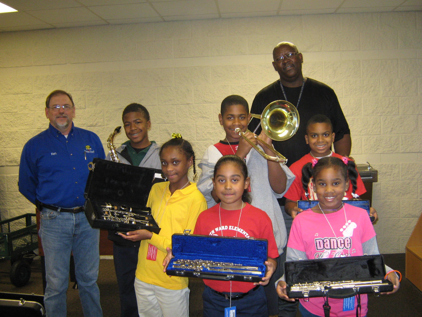 Ken Prine from Insta-Cash Pawn poses with staff and young members of the Longview Texas Boys & Girls Club. The children hold various band instruments.
